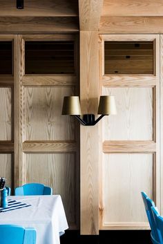 a dining room with blue chairs and wooden paneling