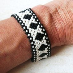 a close up of a person's arm wearing a bracelet with black and white beads