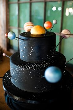 a black cake decorated with planets and stars