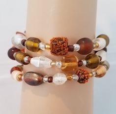 Autumn colors dominate this multi-colored glass bead bracelet on memory wire. Bracelet features amber-colored , clear, golden, brown, orange and white beads in several different shapes and sizes, some are lamp work beads with extra textures. Brown Czech Glass Bracelets With Colorful Beads, Czech Glass Brown Bracelet With Colorful Beads, Brown Czech Glass Bracelet With Colorful Beads, Brown Wire-wrapped Beaded Bracelets For Jewelry Making, Glass Bead Bracelet, Memory Wire Bracelet, Bracelet Women, Glass Beaded Bracelets, Autumn Colors