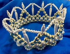 a white and gold tiara with pearls on it