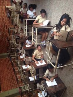 some students are sitting at desks with their laptops