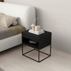 a small black end table next to a bed