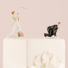 a wedding cake topper with a bride and groom figurine on it's side