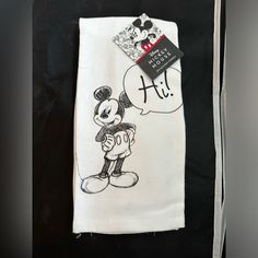 a mickey mouse towel with a tag on it's back and an image of a person holding a balloon