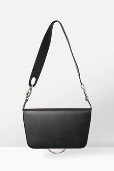 This shoulder bag from Published By combines leather construction with the brand's penchant for dynamic shapes and structure. It has their signature silver-tone ornamentation at the front, completed with a mini silver chain and an oversized leather shoulder strap held by wavy chain clasps. Dynamic Shapes, Silver Logo, South Island, Front Bottoms, Flap Bag, Leather Material, Sale Items, Silver Chain, Zip Pockets