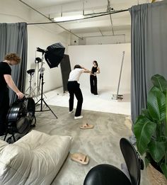 two people are taking pictures in an empty room, one person is standing on the floor