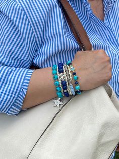 The Seven Seas bracelet is an island inspired piece that features beautiful shades of blue ( turquoise, royal blue and periwinkle) combined with silver beads and enchanting charms. Wear it with your resort outfits to elevate your look! Blue Bracelet For Vacation, Ocean-inspired Blue Bracelets For Vacation, Bohemian Blue Strand Jewelry, Blue Bohemian Strand Jewelry, Adjustable Blue Bracelet For Vacation, Blue Strand Beaded Bracelets As Gift, Blue Strand Beaded Bracelet As Gift, Blue Beaded Strand Bracelets, Blue Strand Bracelets For Vacation