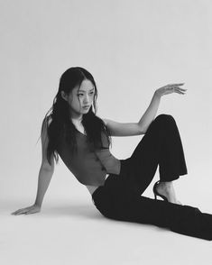 a woman is sitting on the floor with her legs spread out and she is wearing black pants