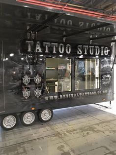 a taco truck parked in a garage with the words tattoo studio on it's side