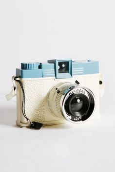 an old camera sitting on top of a white table