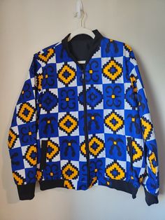 Add a little zing to your wardrobe with this vibrant All-Over Print Bomber Jacket. Wear it on a basic t-shirt, or layer it on top of a warm hoodie--it'll look great either way.  Ankara print jacket made 100% - - cotton fabric - Zipper closure - Size M can fit S - Unisex Trendy Blue Outerwear With Crew Neck, Casual Patchwork Crew Neck Outerwear, Blue Cotton Outerwear With Graphic Print, Cotton Crew Neck Outerwear With Patchwork, Patterned Cotton Outerwear For Winter, Casual Printed Cotton Outerwear, Casual Cotton Printed Outerwear, Printed Cotton Outerwear For Streetwear, Winter Cotton Patterned Outerwear