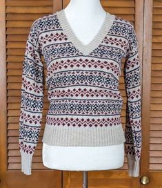 "This is a groovy, vintage 1970s, pullover v-neck sweater in a Scandinavian pattern.  Made in the USA, the sporty sweater is novelty knit in burgundy and navy on a beige \"rag wool\" style background. It is crafted of acrylic yarn. This cool sweater is not marked for size, but is an approximate modern size X-Small/Small, measuring 35\" at the bust, 27\" at the waist, and is 23 1/2\" long from high point of shoulder to waist.  As photographed, it's a very snug fit on the size M (8-10) mannequin. It's in excellent vintage condition, appearing to have seen little use. One great vintage pullover!" Retro V-neck Winter Tops, Vintage V-neck Knit Sweater, Vintage V-neck Sweater For Fall, Casual V-neck Fair Isle Sweater, Vintage Knit V-neck Sweater, Retro Long Sleeve V-neck Sweater For Winter, Sporty Sweater, Cool Sweater, Scandinavian Pattern