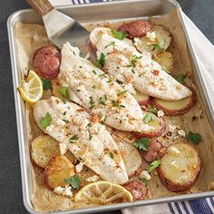 a pan filled with chicken and potatoes on top of a table next to a fork