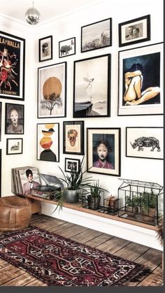 a living room filled with lots of pictures on the wall and a rug in front of it