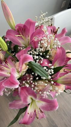 a bouquet of pink lilies and baby's breath