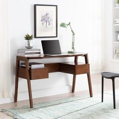 a laptop computer sitting on top of a wooden desk next to a lamp and bookshelf