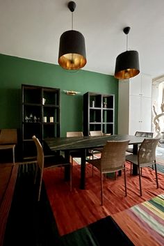 a dining room with green walls and colorful carpet