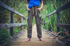 a person standing on a bridge with their hands in their pockets and wearing blue shirt