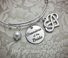 "♥ ✿ ♥ This elegant piece of jewelry will make a beautiful and sentimental gift that will best express your gratitude and love for your grandma. ♥ ✿ ♥ ✿ This piece includes ✿ ♥ disc pendant 20mm engraved with the words \"Grandma of the Bride\" ♥ infinity heart charm that symbolizes \"I love you forever\" ♥ authentic shell pearl (8mm) ♥ adjustable bangle 60mm in size (expandable to fit wrist 7-8\") ✿ Optional necklace (18-inch) OR keychain ✿ Leave a clear instruction at note to seller if you want Adjustable Hallmark Jewelry For Gifts, Mother's Day Gift Bracelet Jewelry For Mom, Mother's Day Bracelet Jewelry Gift For Mom, Mother's Day Gift Bracelet Jewelry, Spiritual Charm Bracelet For Mother's Day Gift, Customized Jewelry For Bridesmaid Gift On Mother’s Day, Customized Jewelry For Bridesmaid Gift On Mother's Day, Mother's Day Gift Bangle Jewelry For Mom, Mother's Day Bangle Gift For Mom