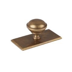 an antique brass door knob with a square base on a white background, the top is shown