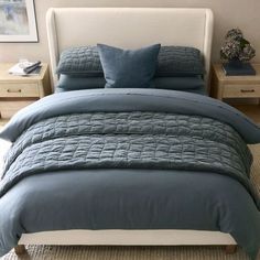 a bed with blue comforters and pillows in a bedroom