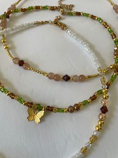 Look beautiful while embracing the spirit of nature with our Forest Fairy Necklaces. A unique blend of hand beaded glass in green, brown and gold, these necklaces are made of glass beads and 14K gold plated beads for lasting wear. Stand tall with nature. Nature Inspired Beaded Jewelry, Green And Gold Beaded Necklace, Gold Bead Jewelry, Beaded Necklace Brown, Forest Fairy Necklace, Brown Beaded Jewelry, Nature-inspired Green Necklace For Festival, Nature-inspired Green Necklace For Festivals, Earthy Gold Beaded Bracelets For Healing