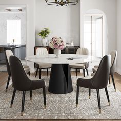 a dining room table with chairs around it and a chandelier hanging from the ceiling