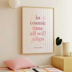 a poster hanging on the wall above a bed in a room with pink and yellow accents