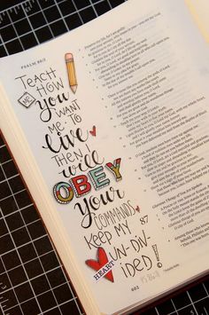 an open bible with hand lettering on it