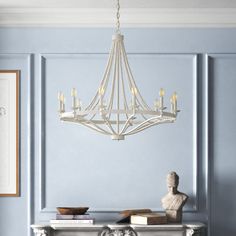 a white chandelier hanging from the ceiling in a room with blue walls and furniture