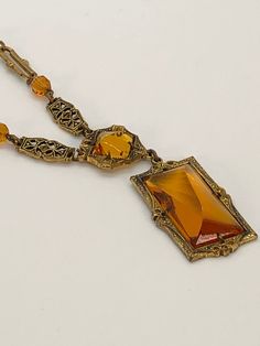 Beautiful Czechoslovakian style 1930-1940 amber colorded glass pendant on a detailed gold tone link chain with amber colorded crystal beads. Dress up or dress down this stunning piece; unmarked. Vintage Yellow Pendant Jewelry, Art Deco Citrine Gold Jewelry, Vintage Orange Citrine Jewelry, Orange Citrine Vintage Jewelry, Vintage Amber Brass Jewelry, Vintage Amber Glass Necklaces, Vintage Glass Pendant Necklace, Antique Glass Necklaces For Collectors, Antique Amber Pendant Necklaces