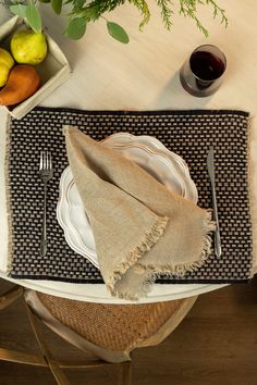 a place setting with plates, silverware and fruit