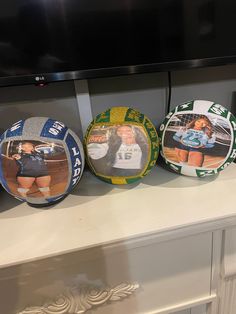 three sports themed plates sitting on top of a white counter next to a tv screen