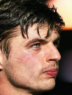 a close up of a man with wet hair on his face looking off to the side