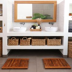 a bathroom with two sinks and baskets on the floor