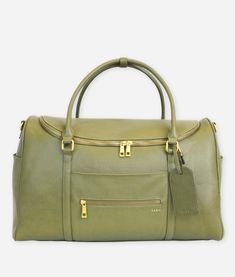 a green handbag with gold handles and zippers