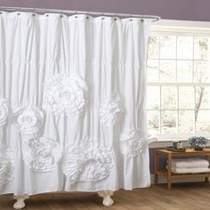 a white shower curtain with flowers on it in front of a blue and purple wall