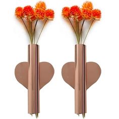 two metal vases with flowers in them on a white background, one is shaped like a heart