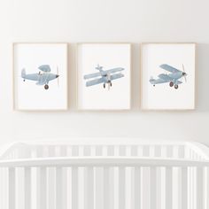 three framed photos of airplanes hang on the wall above a crib