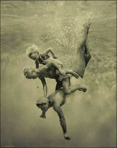 an old photo of two people in the water