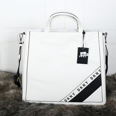 Nwt Dkny Bond North South Tote White Purse New With Tags. No Visible Flaws. Add A Little Elegance To Your Everyday With The Dkny Duane Tote. The Take-Anywhere Silhouette Has What It Takes To Hold All Your Essentials While Polished Hardware Adds The Perfect Dose Of Refinement. Could Be A Great Messenger Bag Or Small Laptop Bag! Large Sized Bag; 14-1/2"W X 13-3/4"H X 4-1/2"D 22"L Adjustable Strap Silver-Tone Exterior Hardware 1 Interior Slip Pocket & 1 Zip Pocket Faux Leather Paper Bag Waist Pants, Dkny Bags, Dkny Bag, Work Tote Bag, Small Laptop, White Purse, Red Tote, Work Tote, White Purses