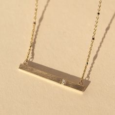 The 14k gold GNAR necklace features a slender bar with our signature satin finish and 2 offset white diamonds. Chain is attached. A perfect layering addition to the CHAI, GORP and GORY necklaces. Chain is 14k gold 1.0mm ice cube sparkle chain Necklace length is 16" Full cut round white diamonds, approximately .014 ctw Horizontal bar is approximately 30mm x 3mm Designed and hand forged in our studio in coastal Southern California Complimentary ShippingReturns and Exchanges 14k Gold Bar Necklace, California Colors, Gold Bar Necklace, Necklace Chain Lengths, Color Swatch, Gold Bar, White Diamonds, Bar Necklace, Satin Finish