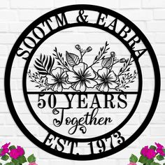 a metal sign that says, 50 years together established in black and white with flowers on it