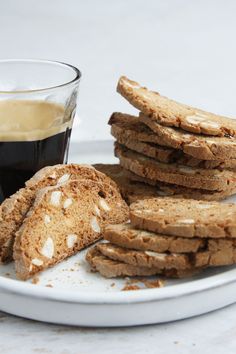 a white plate topped with cookies next to a cup of coffee