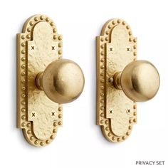 two brass door knobs with rivets on each one and an oval handle