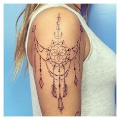 a woman's arm with a tattoo on it and an image of a dream catcher