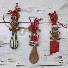 three wooden spoons with christmas decorations hanging from them