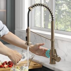 a woman is washing her hands under the kitchen faucet with fruit on the counter