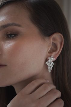 a close up of a person wearing some kind of earring with flowers on it